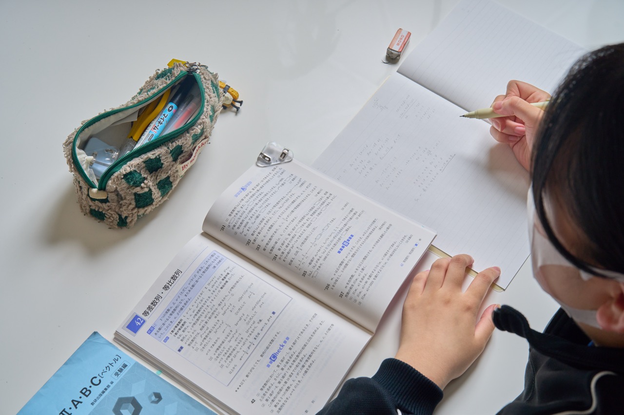 答案とノートを見ながら数学のつまずきを確認している手元